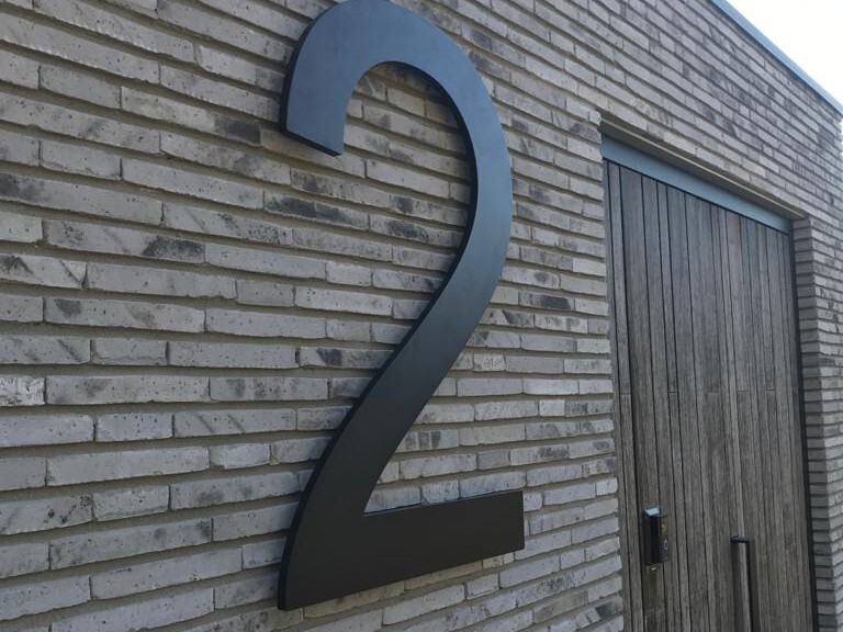 Close-up van het grote huisnummer op de gevel van deze villa. Ook een groot huisnummer op maat? Laat je freescijfers op maat maken door Tijs Reclameproductie in Beuningen